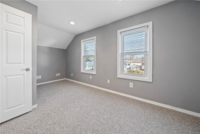 additional living space with vaulted ceiling and carpet