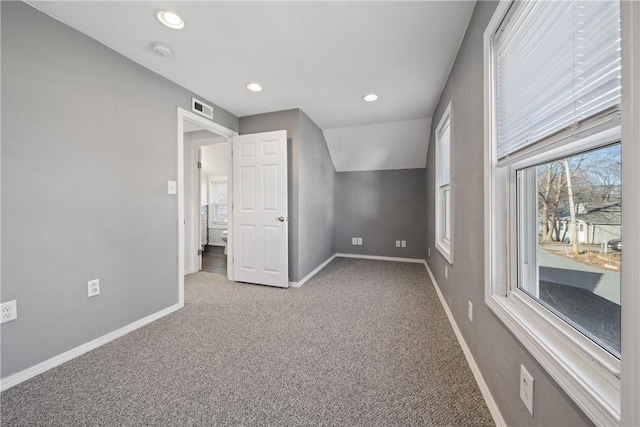 unfurnished bedroom with vaulted ceiling and carpet floors