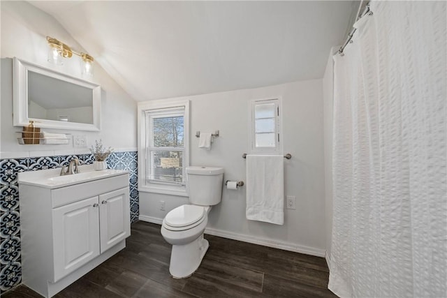 bathroom featuring lofted ceiling, vanity, wood-type flooring, and toilet