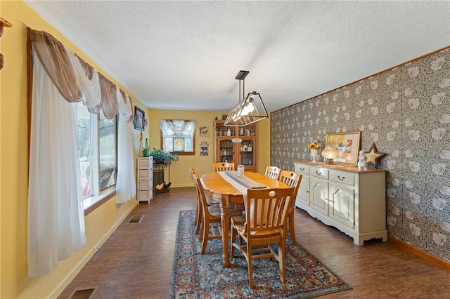 dining area with dark hardwood / wood-style floors and a textured ceiling