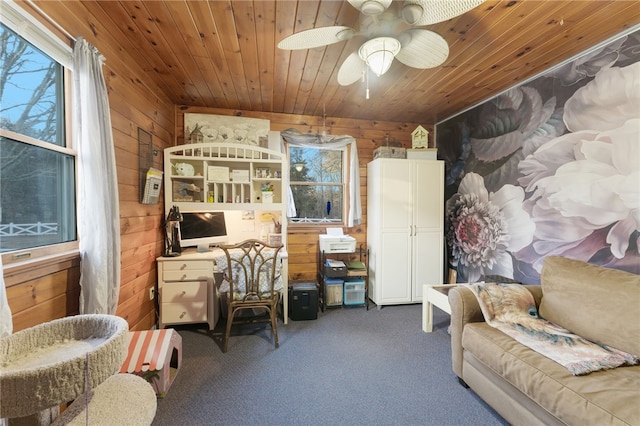 carpeted office space with ceiling fan, wooden ceiling, and wooden walls