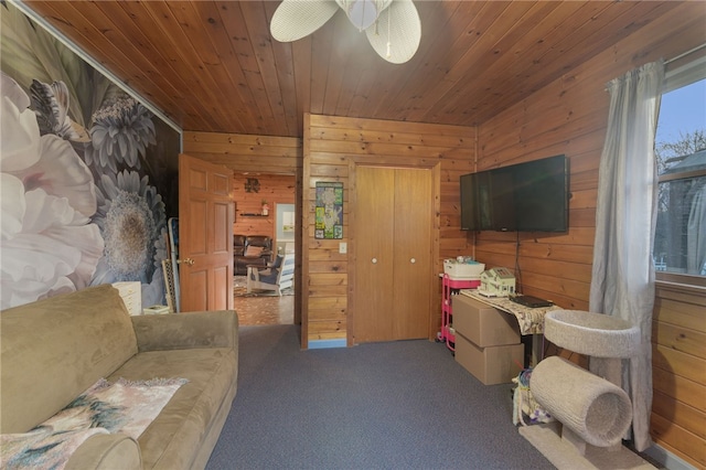 carpeted living room with wood ceiling and wooden walls