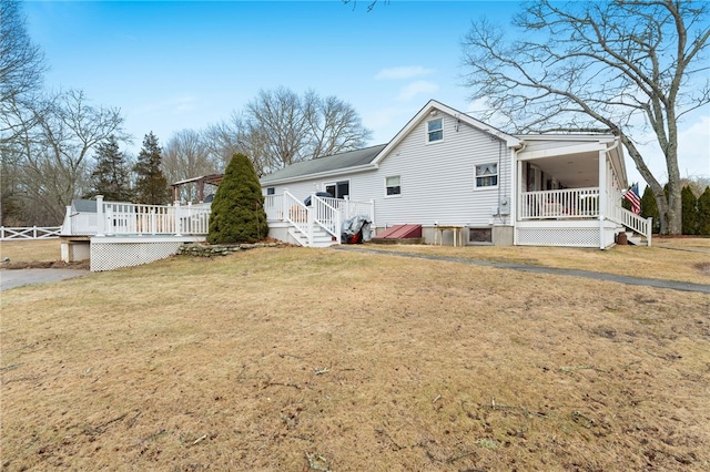 view of side of property featuring a wooden deck and a yard