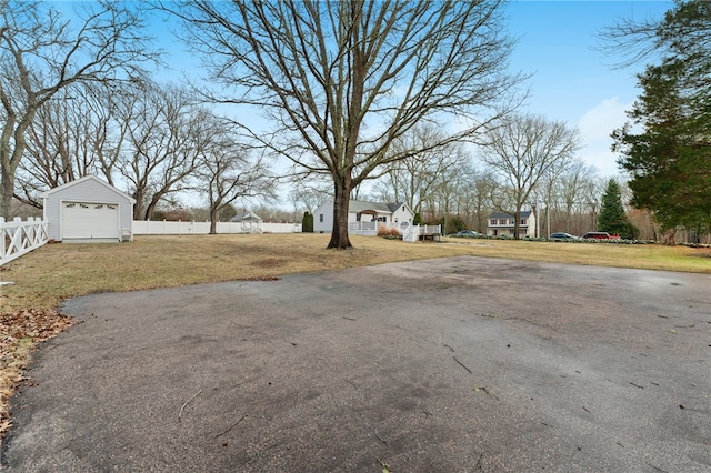 view of yard with a garage and an outbuilding