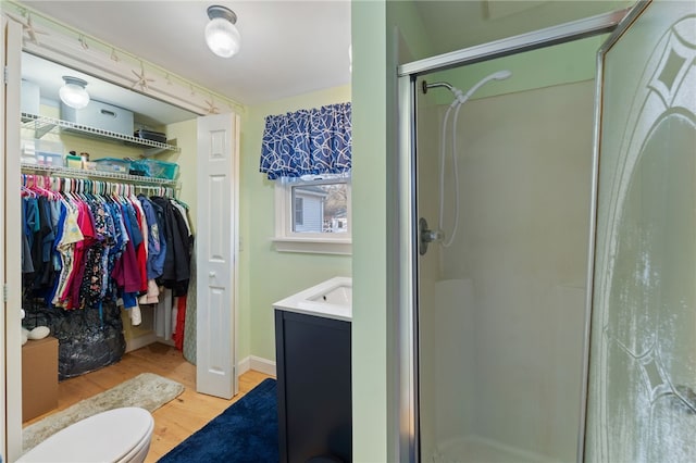 bathroom with vanity, hardwood / wood-style floors, toilet, and walk in shower