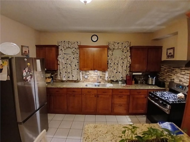 kitchen with tasteful backsplash, sink, light tile patterned floors, and appliances with stainless steel finishes