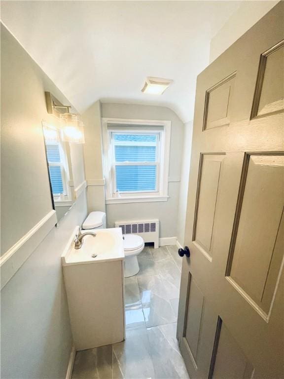 bathroom featuring vanity, vaulted ceiling, radiator, and toilet