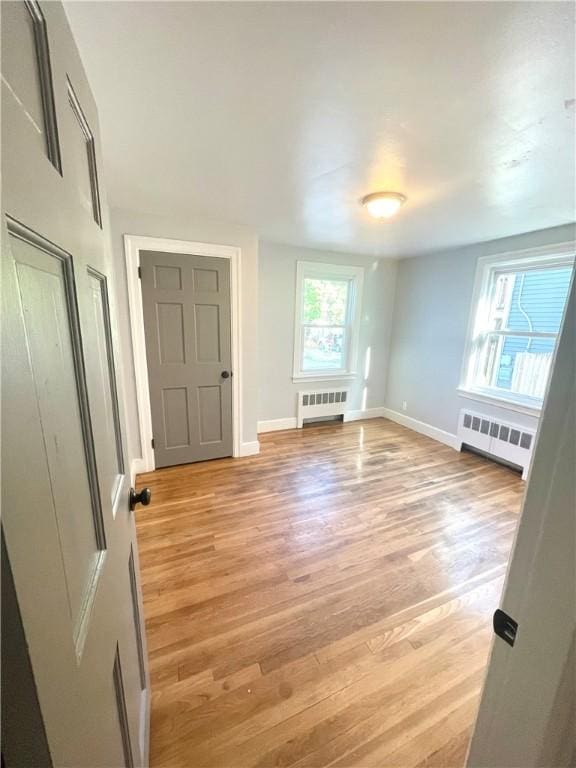 interior space with radiator and light hardwood / wood-style floors