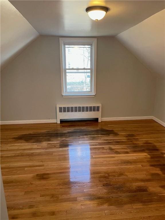 bonus room featuring hardwood / wood-style floors, vaulted ceiling, and radiator heating unit