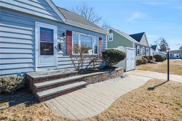 view of exterior entry with a lawn