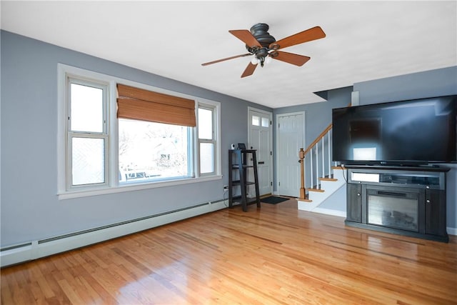 unfurnished living room featuring ceiling fan, a baseboard radiator, and hardwood / wood-style floors