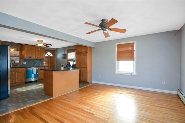 kitchen with tasteful backsplash, a center island, light wood-type flooring, ceiling fan, and stainless steel appliances