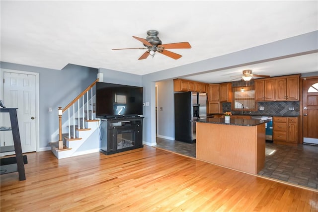 kitchen with a kitchen island, sink, ceiling fan, stainless steel appliances, and light wood-type flooring