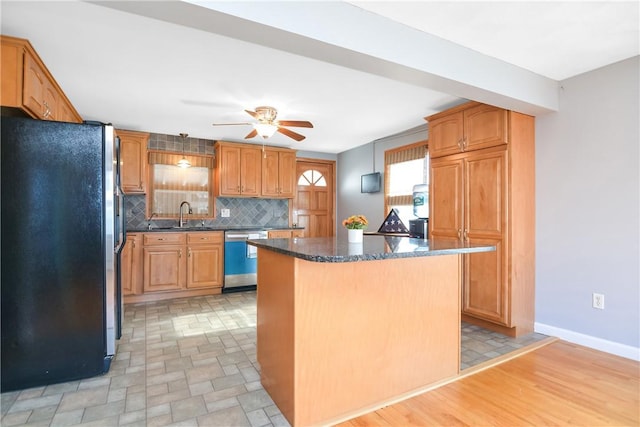 kitchen with ceiling fan, appliances with stainless steel finishes, a center island, tasteful backsplash, and dark stone counters