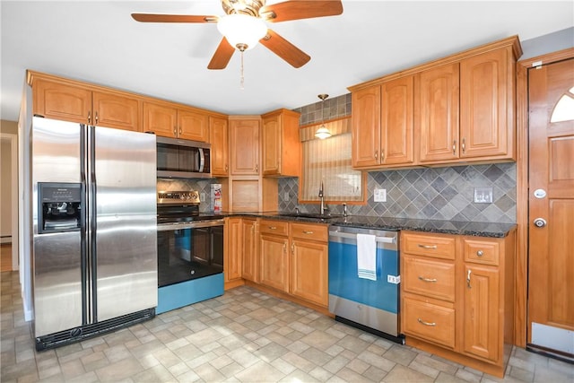 kitchen with sink, ceiling fan, dark stone countertops, stainless steel appliances, and tasteful backsplash