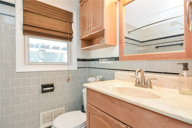 bathroom with tile walls, vanity, and toilet