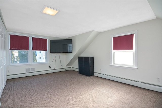 additional living space with plenty of natural light, carpet, and a baseboard heating unit