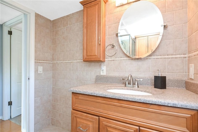 bathroom featuring vanity and tile walls