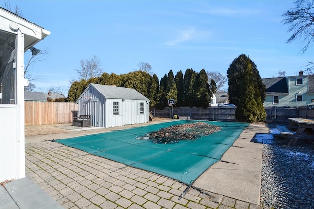 view of pool with a patio and a shed