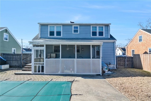 back of property with a patio area and a sunroom