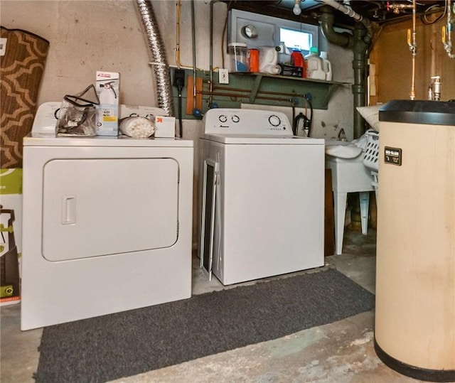 clothes washing area with water heater, washer and dryer, and sink