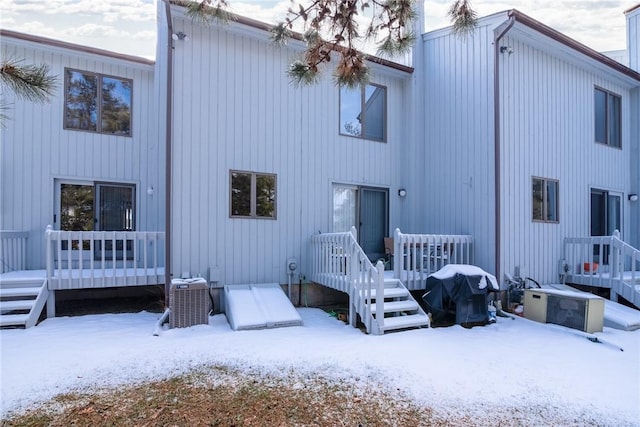 snow covered property with a deck