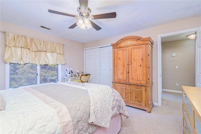 bedroom featuring ceiling fan, a closet, and light carpet