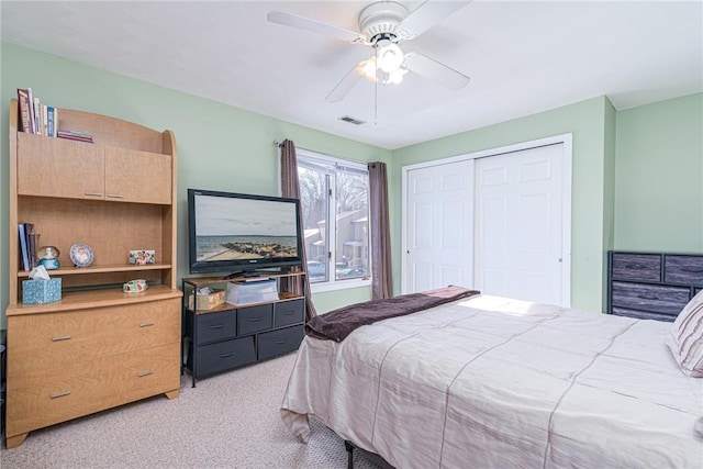 carpeted bedroom featuring a closet and ceiling fan