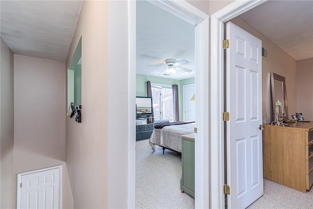 hallway featuring light colored carpet