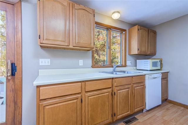 kitchen with sink, white appliances, and light hardwood / wood-style flooring