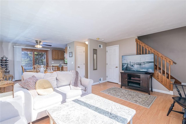 living room with ceiling fan and light wood-type flooring