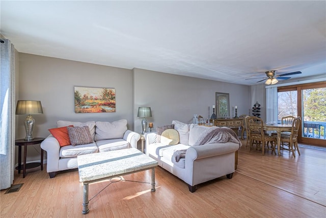 living room featuring ceiling fan and light wood-type flooring