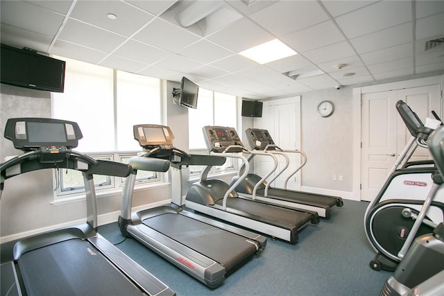 gym featuring a paneled ceiling and a healthy amount of sunlight