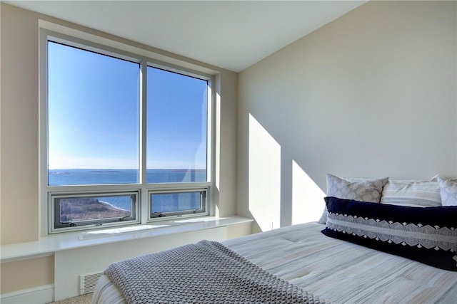 bedroom with multiple windows and a water view