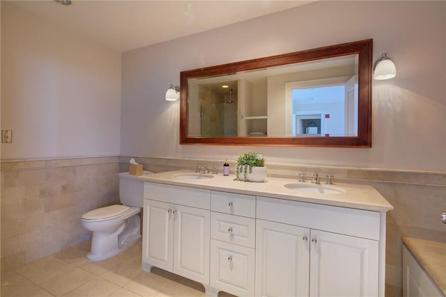 bathroom with tile patterned flooring, vanity, a shower with door, and tile walls