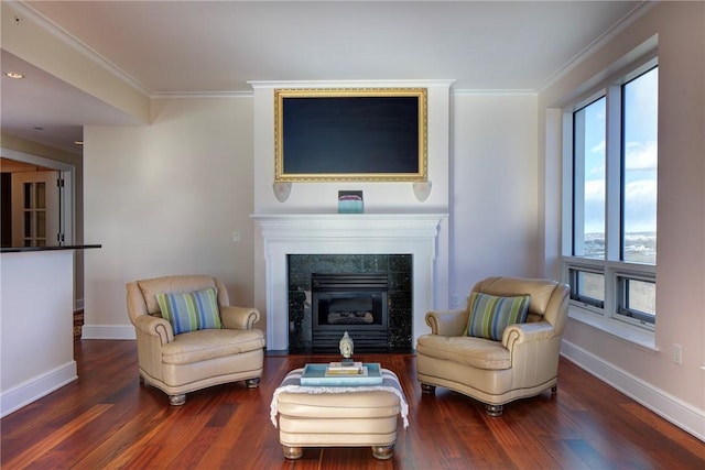 sitting room featuring crown molding, dark wood-type flooring, and a tile fireplace