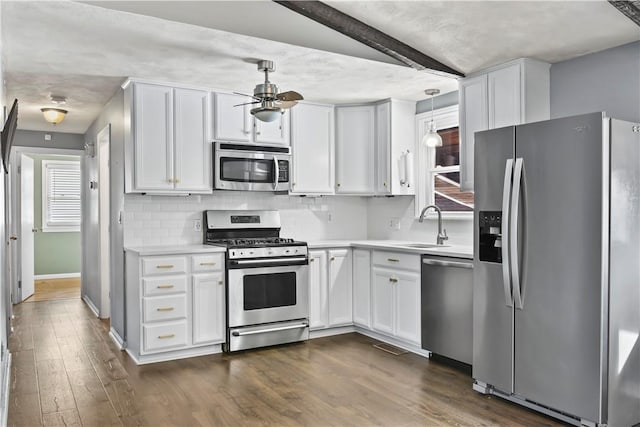 kitchen with pendant lighting, white cabinetry, dark hardwood / wood-style flooring, and stainless steel appliances