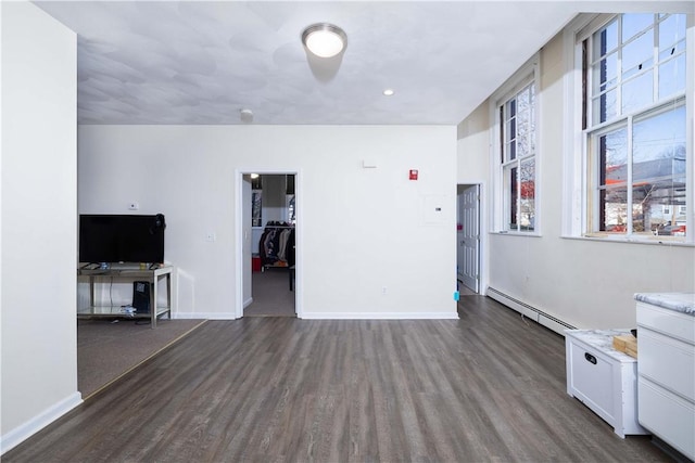 unfurnished living room featuring dark hardwood / wood-style floors and baseboard heating