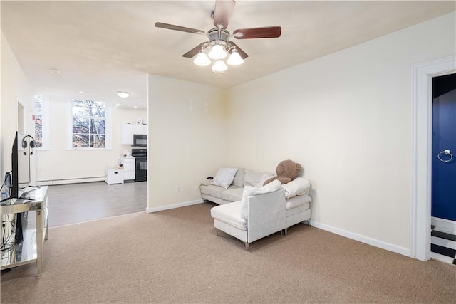 living room with a baseboard radiator, carpet flooring, and ceiling fan