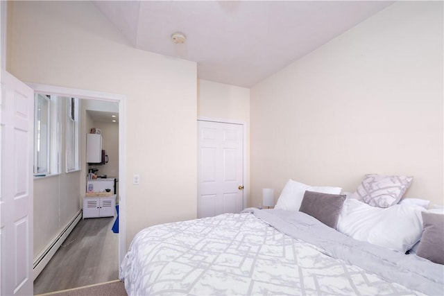 bedroom with baseboard heating and dark hardwood / wood-style flooring