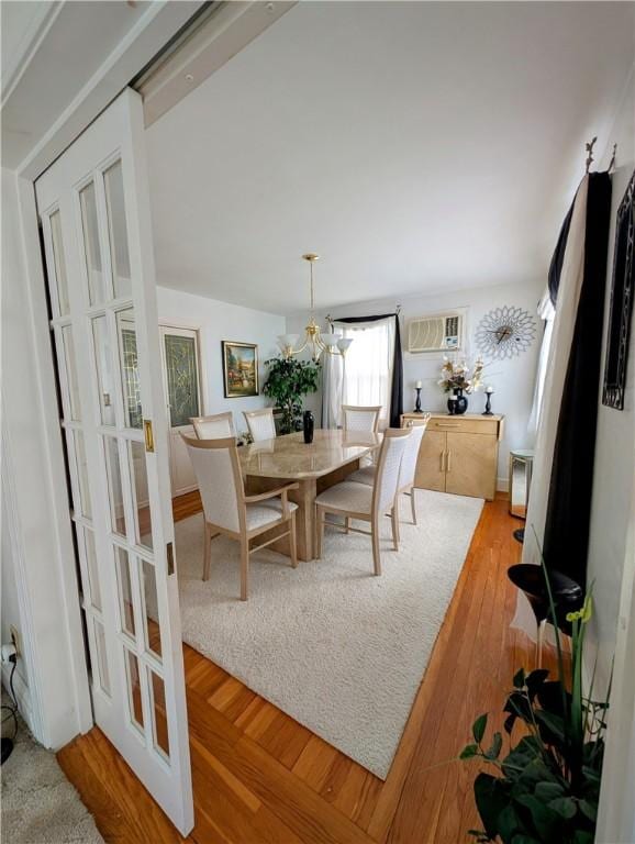 dining space featuring light hardwood / wood-style flooring and an AC wall unit