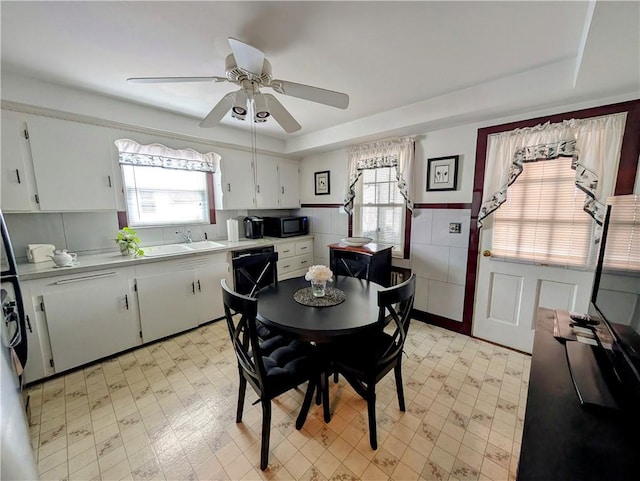 dining space featuring sink, a tray ceiling, and a wealth of natural light