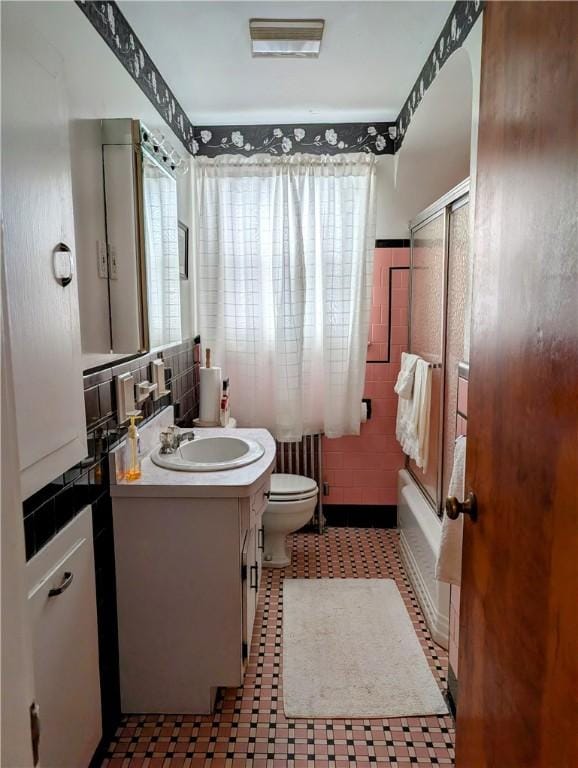 full bathroom with vanity, tub / shower combination, tile walls, and toilet