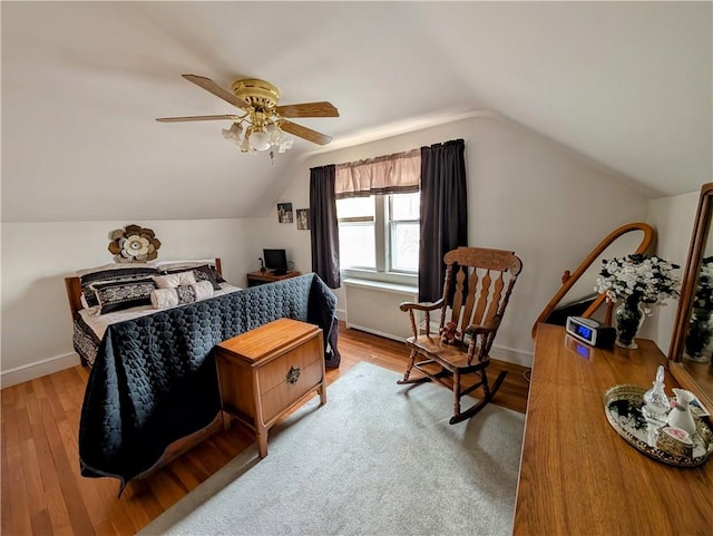 bedroom with ceiling fan, wood-type flooring, and vaulted ceiling