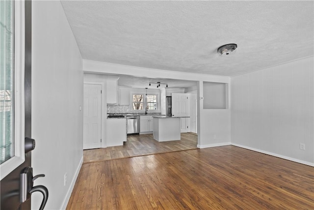 unfurnished living room featuring hardwood / wood-style flooring and a textured ceiling