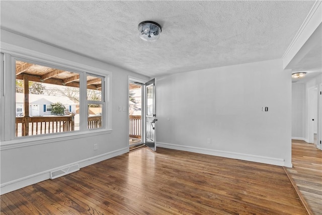 unfurnished room featuring hardwood / wood-style floors and a textured ceiling