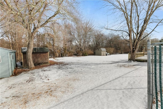 yard covered in snow with a storage shed