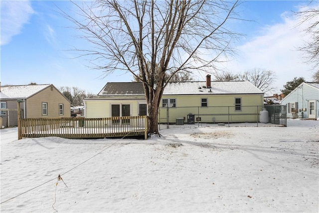 snow covered property with a wooden deck and central air condition unit