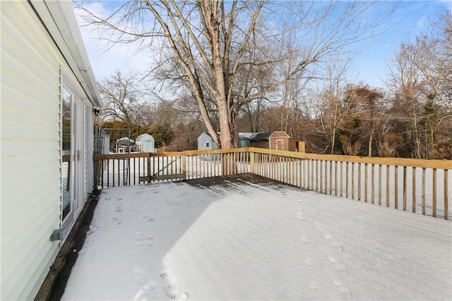 snow covered deck featuring a shed