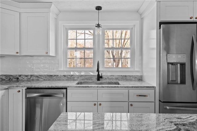 kitchen featuring white cabinetry, appliances with stainless steel finishes, sink, and light stone counters